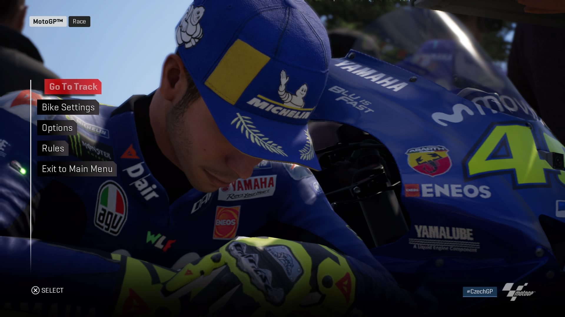  width=1920 height=1080 /></p><p>در نگاه اول می‌توان گفت که روند Moto GP 18 همانند سایر بازی‌های مایل استون بوده که این بار به شکل شبیه‌ساز موتورسیکلت جریان دارد. سازنده سعی کرده در سبک رقابتی- ورزشی یک عنوان جذاب خلق کند، هر چند باید گفت در هدف خود ناموفق بوده است. با توجه به سبک رقابتی بودن، این عنوان در بعضی از موارد مانند طراحی پیست‌ها، چیزی از سایر عناوین ریسینگ کم ندارد، اما در بسیاری از بخش‌های دیگر ناقص بودن این عنوان به وضوح به چشم می‌آید. در واقع باید گفت که مایل استون طی نه ماه گذشته، سه عنوان رقابتی-ورزشی را وارد بازار جهانی کرده است و به نظر می‌آید که با توجه به تعدد عنوان‌های در دست ساخت، نمی‌تواند برای بهبود کیفیت این عنوان، وقت کافی صرف کند. MotoGp 18 برخلاف Monster Energy Supercross از گیم‌پلی ساده‌ای بهره‌مند است و سعی می‌کند با وجود سبک شبیه‌ساز، با ساده کردن برخی المان‌ها بازیکنان را به انجام بازی ترغیب نماید. در نگاه اول این ایده شاید مشکلی نداشته باشد ولی بعد از انجام چند مسابقه و دیدن هوش مصنوعی ضعیف رقبا، ساده بودن به یکی از نقاط ضعف بازی تبدیل شده و موجب می‌گردد که روند آن پس از چند ساعت به شدت تکراری شود. سیستم مکانیزم گیم پلی از دو بخش اتوماتیک و دستی بهره‌مند است به طوری که برای افرادی که تازه کار هستند، سیستم اتوماتیک خیلی می‌تواند کاربردی باشد. مثلا سر پیچ های تند، موقع تعویض دنده‌ها، رفتن به پیت ( جایگاه) به صورت اتوماتیک برای تعویض تایرها و… که کنترل این سیستم به صورت دستی کار بسیار مشکل و طراحی شده برای افراد حرفه‌ای تر است. دقیقا مثل عناوین قبلی این استودیو بازیکن می‌تواند قبل از شروع مسابقه، شرایط جوی را از طریق گزارشگر بازی بررسی کند و برای هر شرایط جوی خاص، مثل آسفالت‌های خیس و لغزان، نوع تایر موتور خود را عوض کند یا از قدرت موتور کاسته تا در پیچ‌های مارپله‌ایی، از آن شرایط جان سالم بدر ببرد و با موانعی بر خورد نکند.</p><p><img loading=lazy decoding=async class=